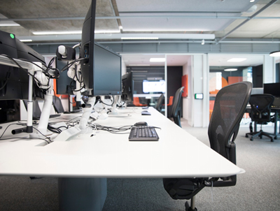 modern office workspace with multiple computer monitors and ergonomic chairs providing collaborative work environment for productive teams