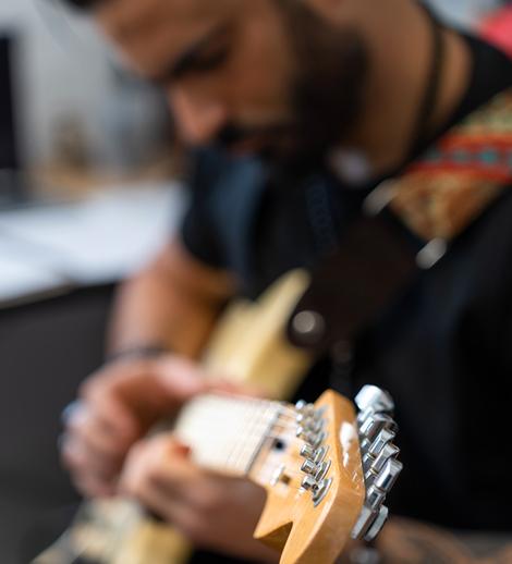 a person playing an electric guitar with a blurred background showcasing musical creativity and passion for music